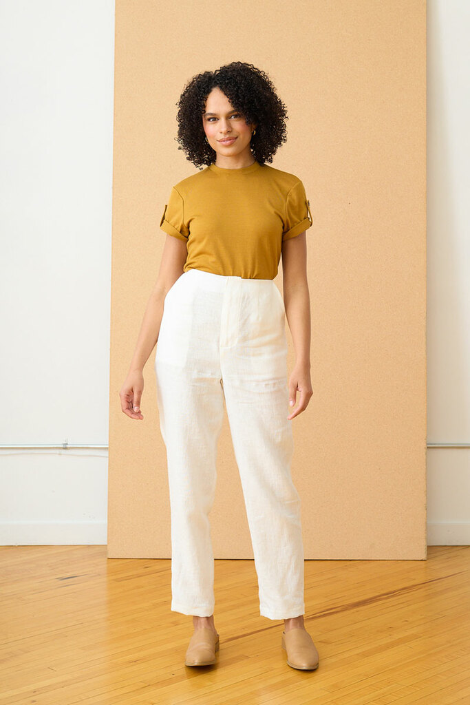 A model wearing the Erin tapered trousers in white and the Jane tee in yellow