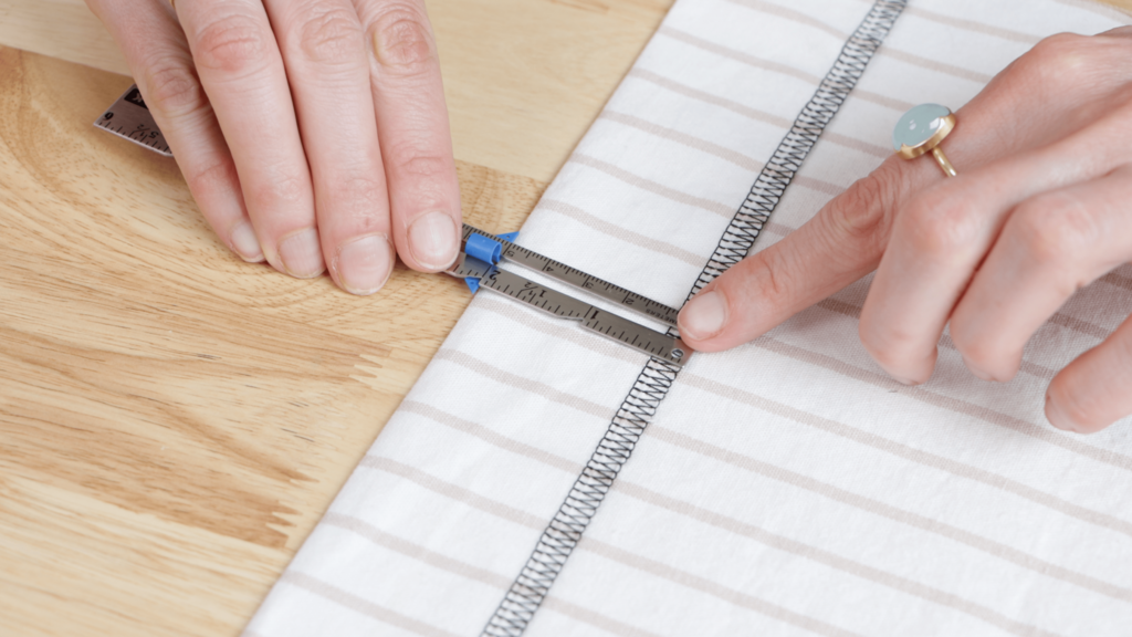 hem allowance being measured with a seam gauge, showing consistent 2-inch depth