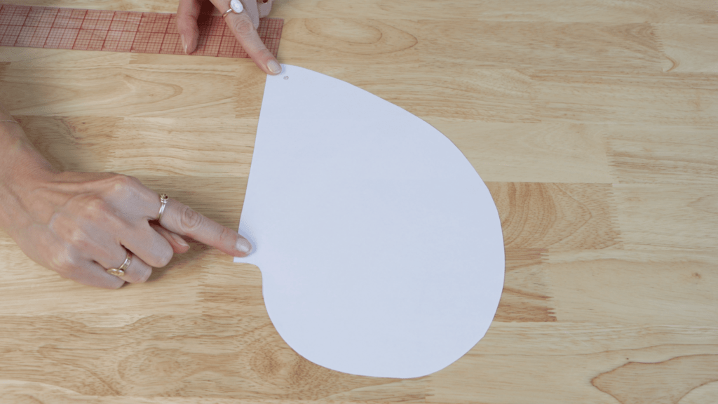 Pocket template with pivot points marked and hole punch creating marking holes
