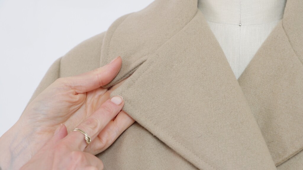 Close-up of perfectly even topstitching along coat edge
