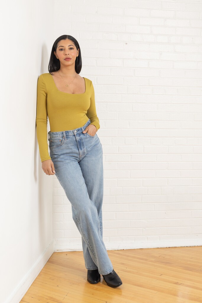 Woman wearing a green Ione bodysuit