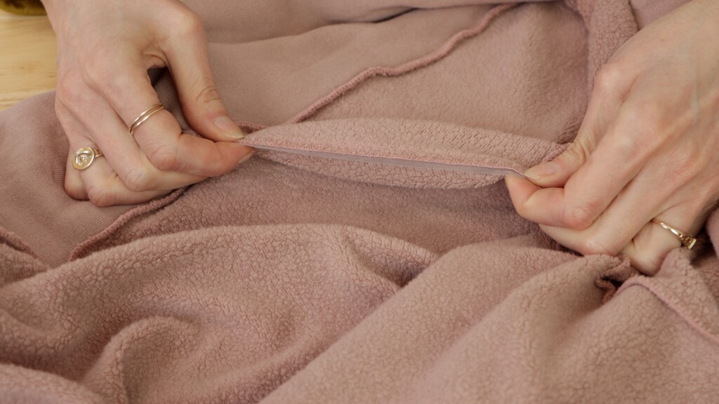 Clear elastic being sewn into a shoulder seam to prevent stretching