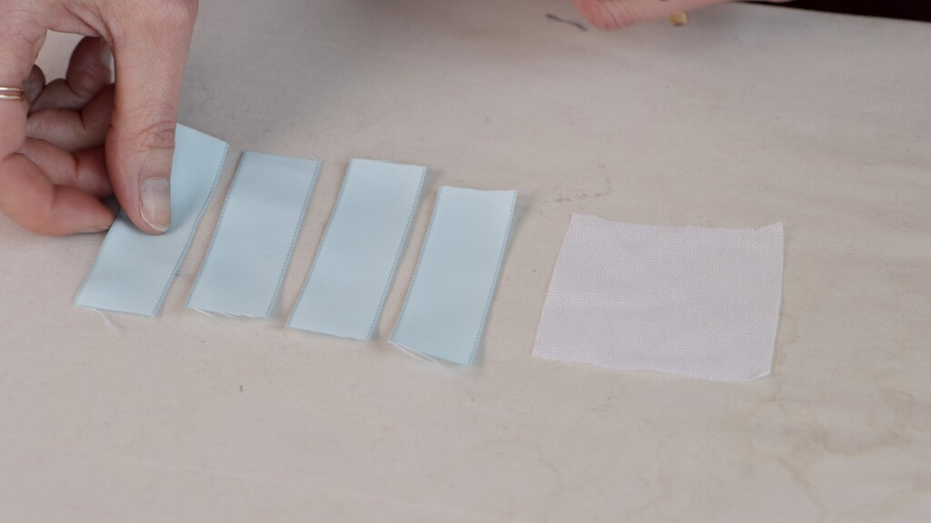 Four ribbons laid out ready for weaving, with sheer interfacing as foundation
