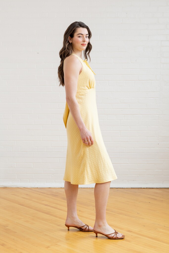 Model wearing yellow Freesia dress in side view