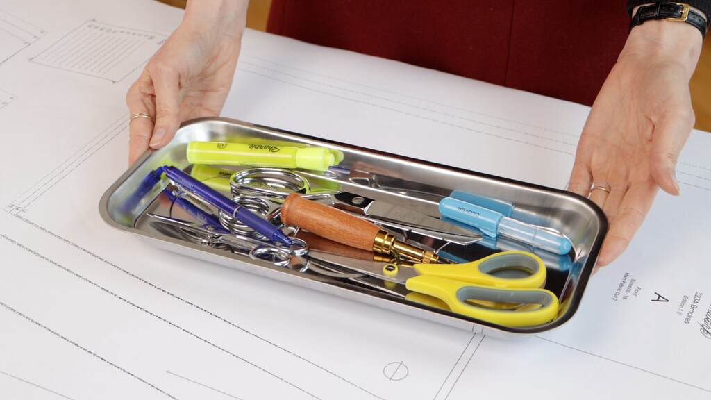 organized cutting tray containing fabric scissors, paper scissors, thread snips, and other cutting tools neatly arranged