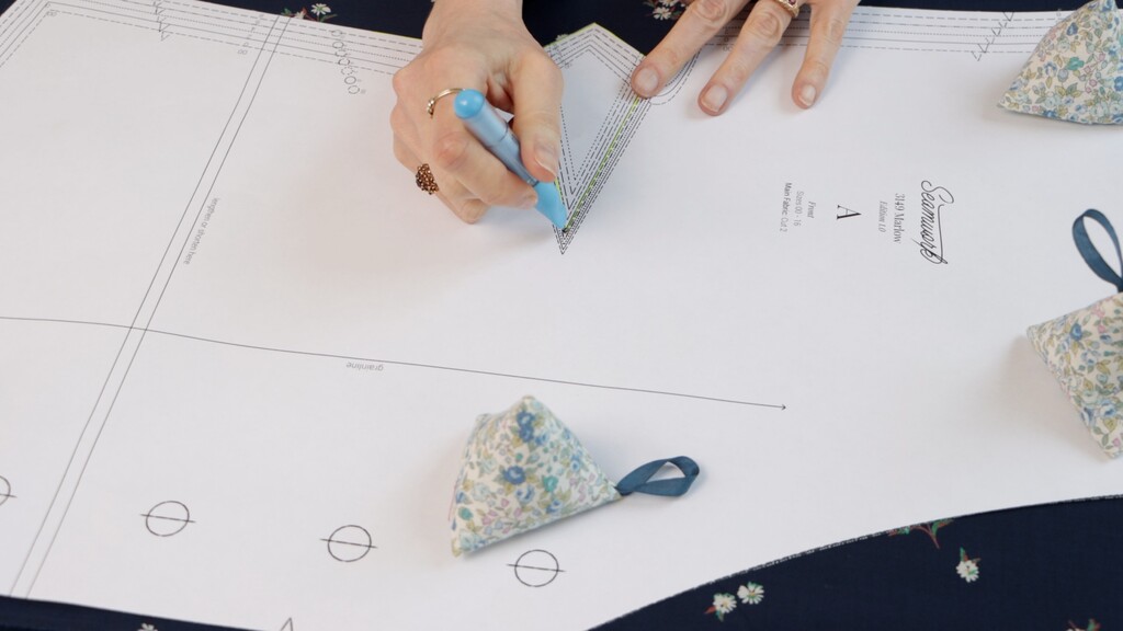 fabric with several small chalk marks visible through pattern holes, showing precise marking placement