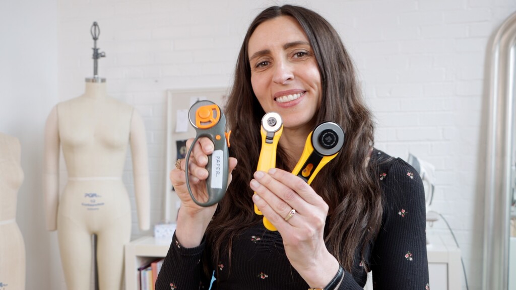 collection of different sized rotary cutters and various pattern weights including washers and fabric-covered weights