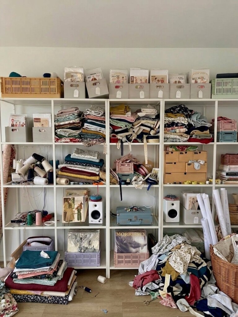 Before photo of cluttered sewing room with fabric scraps, tools, and notions scattered across surfaces