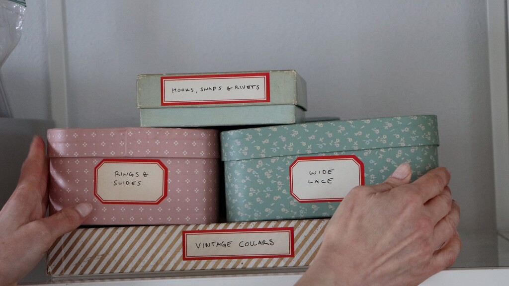Stack of vintage gift boxes with side labels for organized storage