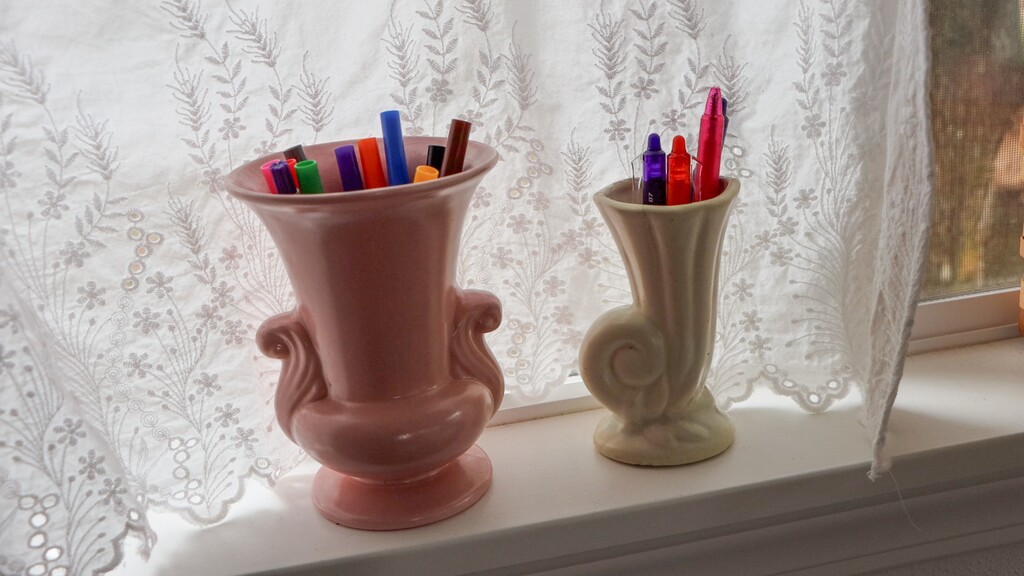 Vintage ceramic vase holding scissors, seam rippers, and other sewing tools