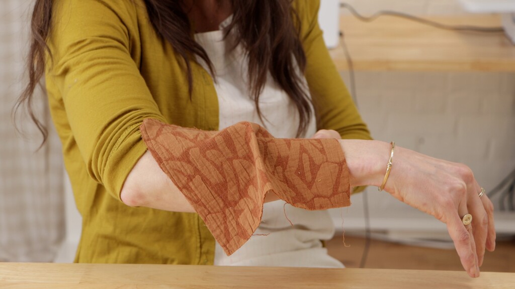 Hands testing fabric drape with swatches