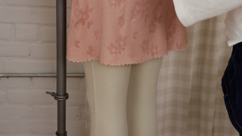 Close-up of the skirt hem showing the scalloped edge in motion, with fabric gently flowing