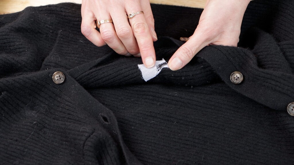Close-up of hands mending a garment at a sewing machine