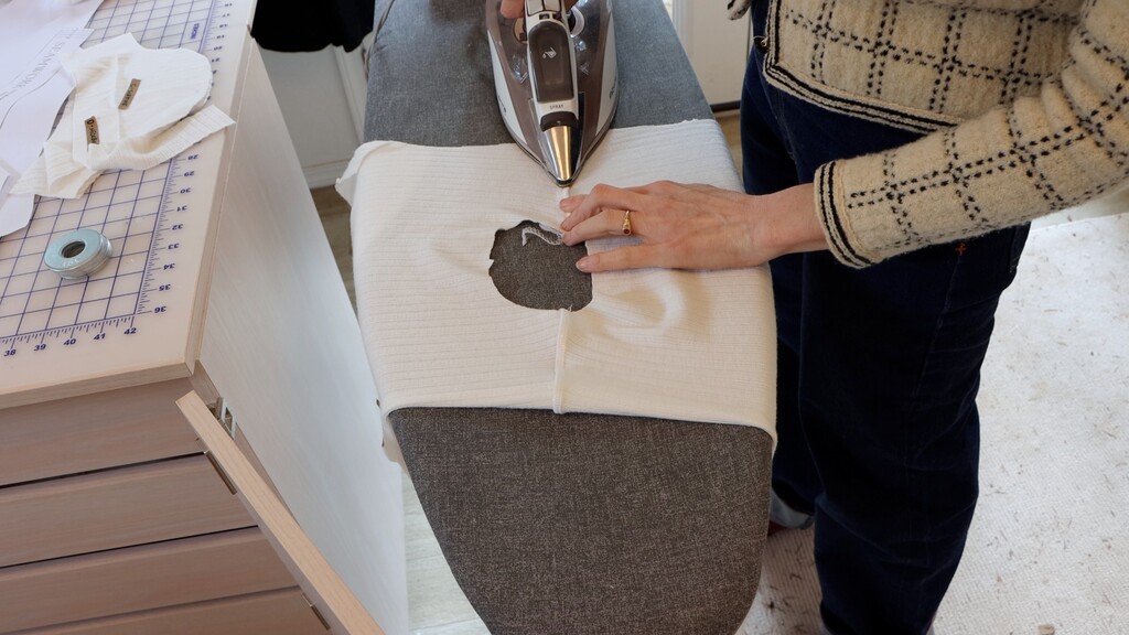Shoulder seam being pressed toward the back with an iron, showing stabilizer strip within the seam allowance