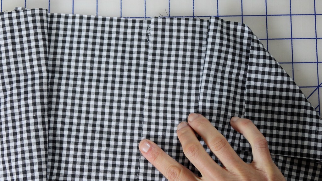 Close-up of center front seam on a completed gingham garment showing aligned checks, shot straight o