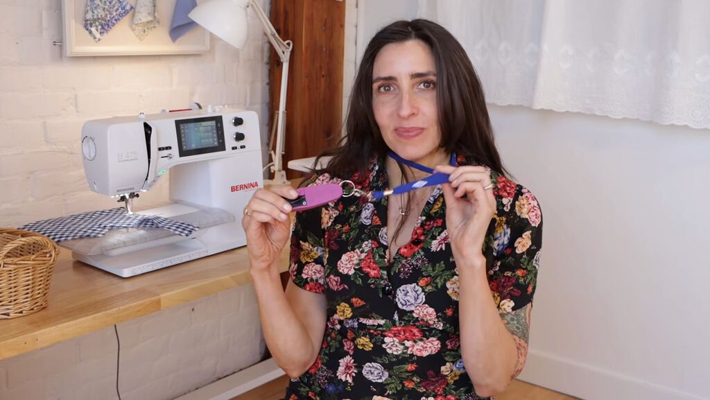 Thread snips hanging from a ribbon lanyard around Sarai's neck