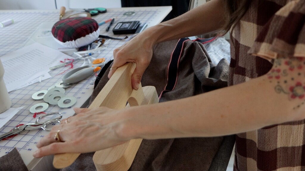 Close-up of a bulky seam being pressed with a clapper, showing the tool in action